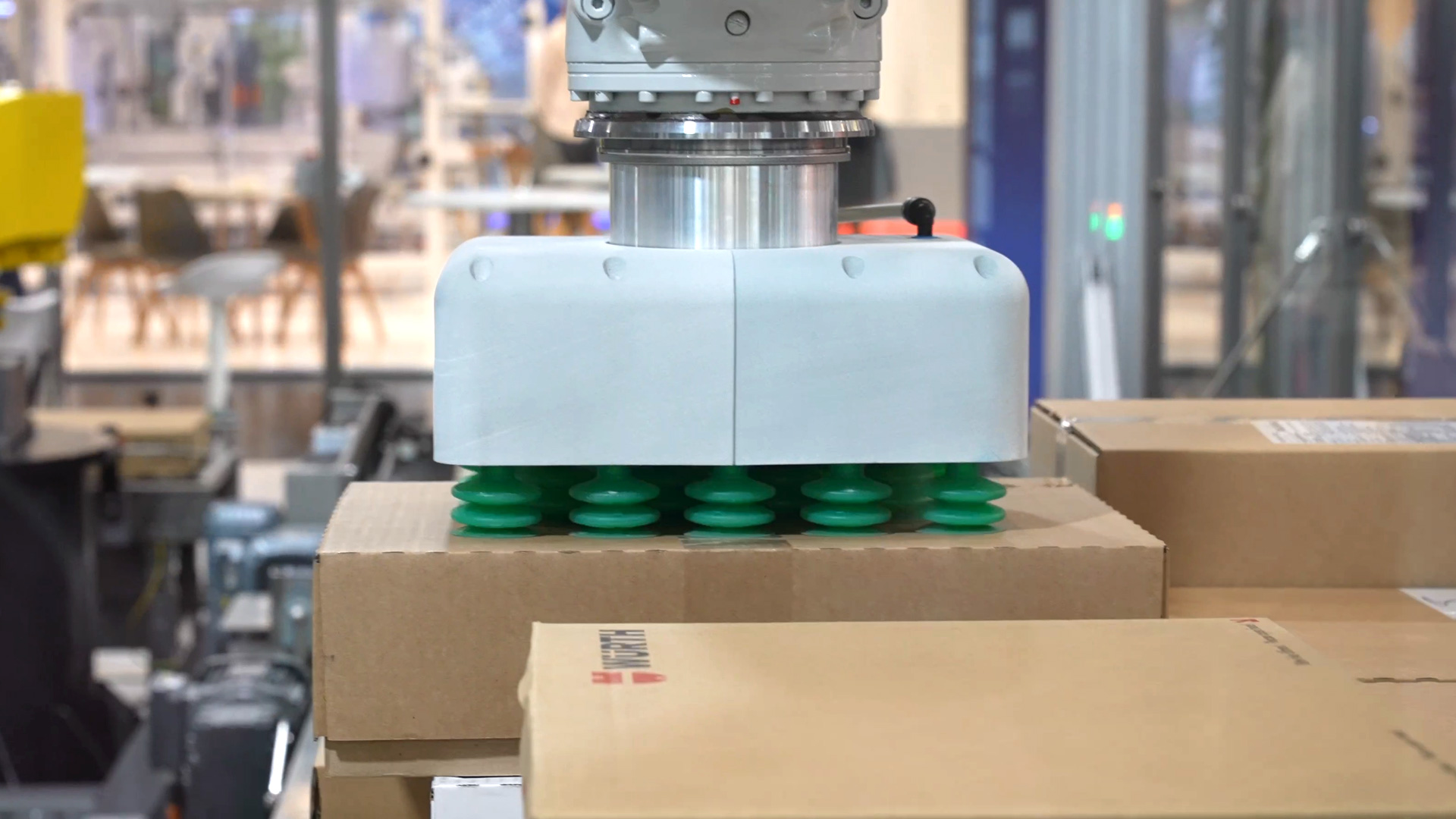 Robotic arm packs different cardboard boxes with suction feet