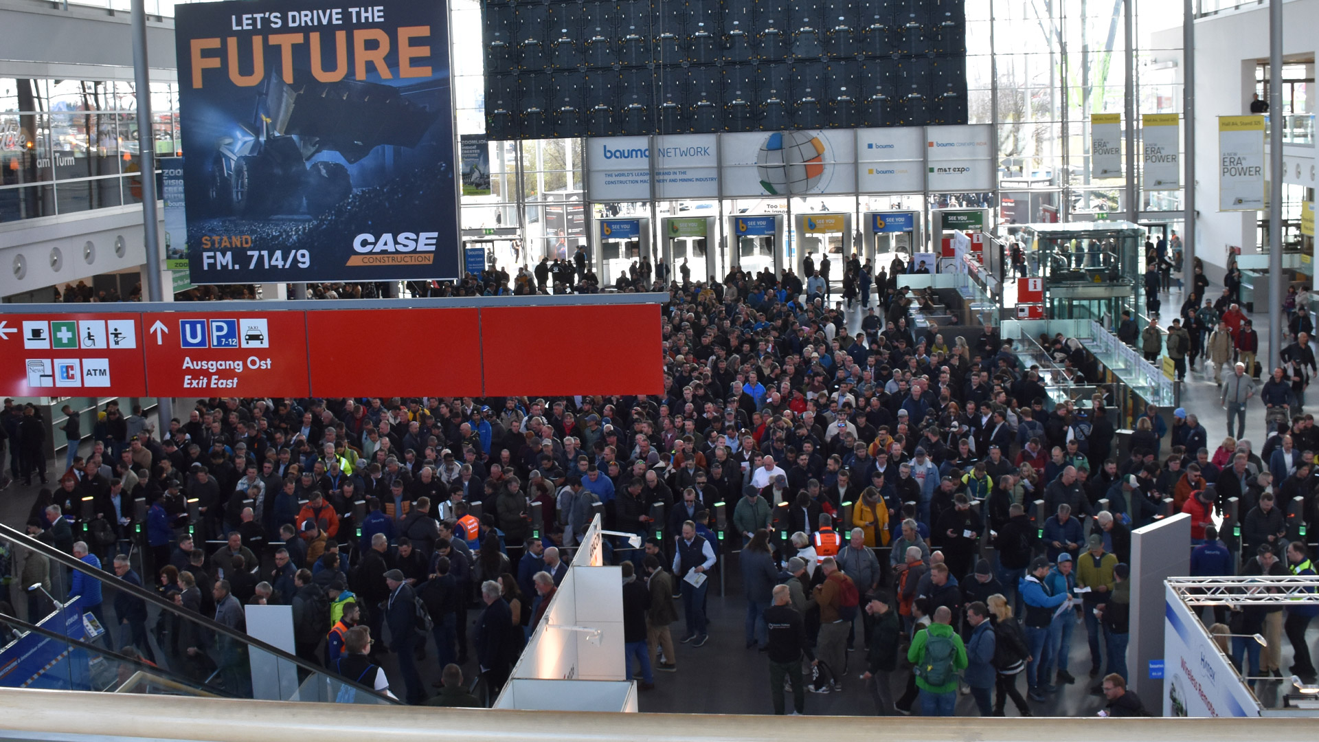 Internationale Fachbesucher auf der bauma im Gespräch vor Baumaschinen und Ausstellerständen – Symbol für globalen Austausch und Branchentrends.