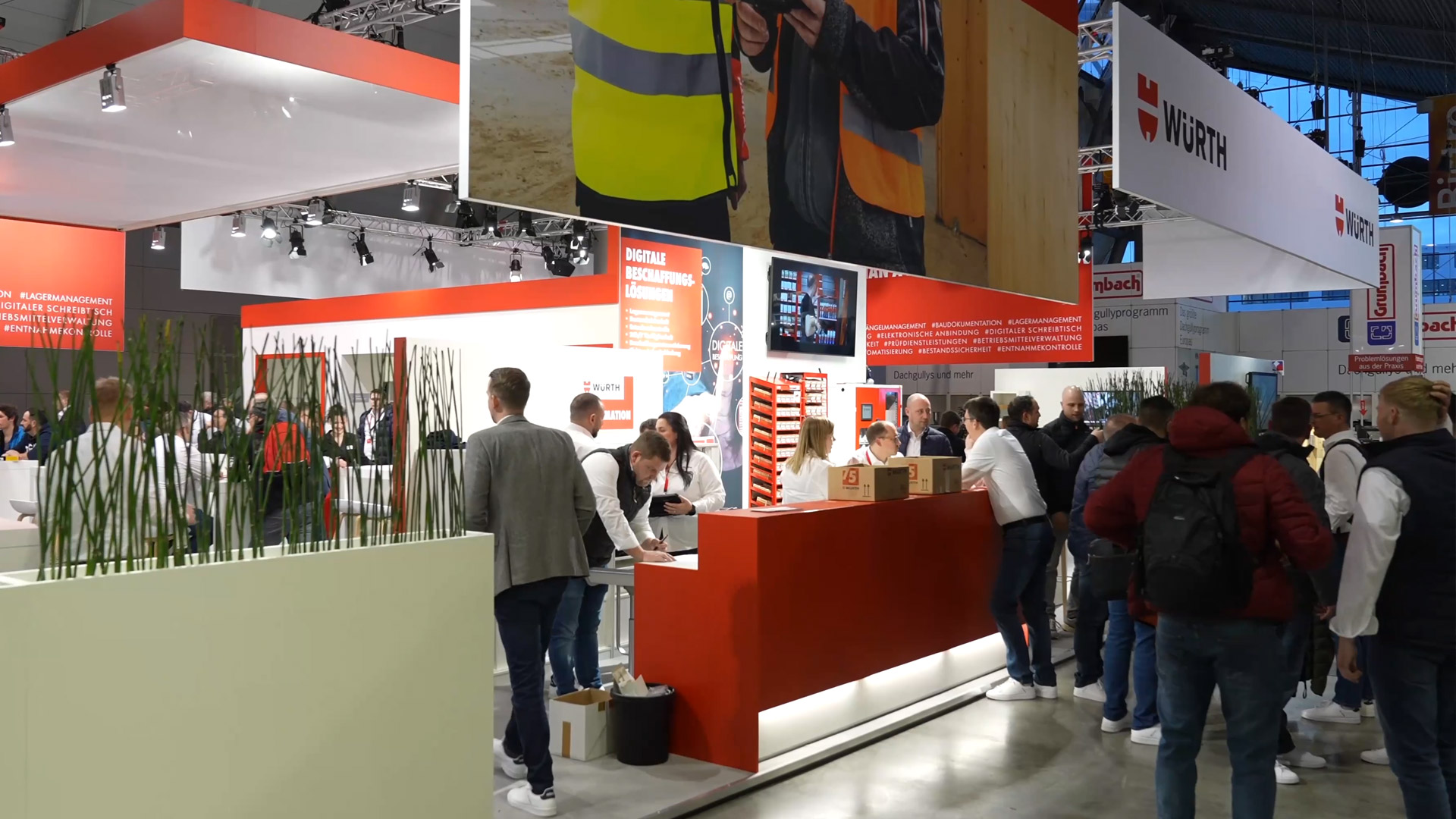 Besucherinnen und Besucher vor dem Haupteingang der Messe Stuttgart an einem sonnigen Tag, mit Glasfassade und Messebannern im Hintergrund.